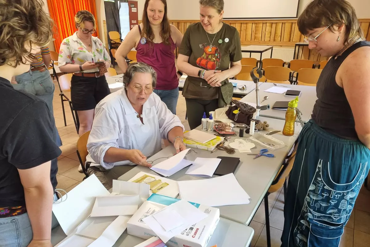 Begeleider Rona geeft een workshop boekbinden.