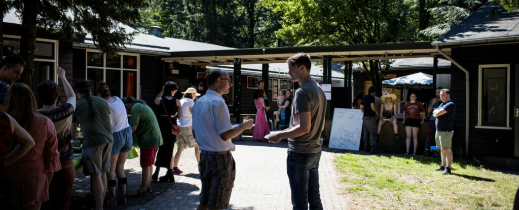 Deelnemers staan te praten voor de locatie terwijl lunch geserveerd wordt.