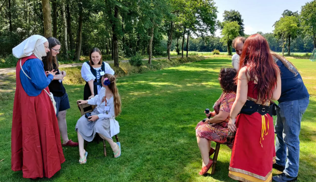 Twee groepjes mensen praten onderling op een grasveld tijdens een short larp.